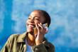 © Paula - Joyful young African woman on phone call smiling under sunlight