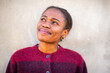 © Paula - Thoughtful African young woman smiling and looking up