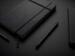 © Madep - A black notebook and pens on a dark surface