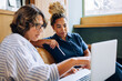 © (JLco) Julia Amaral - Two women discussing work together while looking at a laptop screen