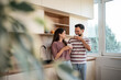 © Migma_Agency - Happy couple drinking milk in modern kitchen, enjoying morning routine together