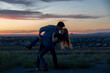 © Allison - A man tenderly kisses a woman he holds in his arms at sunset