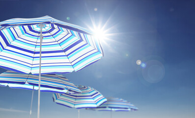 Wall Mural - bright striped beach umbrellas against blue sky on sunny day