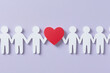 © photo for everything - Paper cut-out figures holding hands, with a red heart representing love and unity on a light purple background. Symbolizing connection and support.