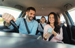 © Prostock-studio - Car navigation app. Happy woman showing gps application on cellphone to driver man, family travelling and navigating vehicle with gadget, enjoying weekend trip