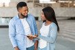 © Prostock-studio - Black female volunteer conducting survey with young man on the street and writing down answers to clipboard, selective focus