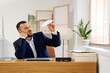 © Pixel-Shot - Bored businessman with paper plane at table in office