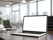 © amaf - Modern laptop with blank screen sits on a wood desk in a bright, minimalist office, near a coffee cup and papers, overlooking a city