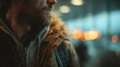 © xuxu - Man with a beard wearing a winter coat, looking pensive in city lights at night, traveler in urban bokeh.