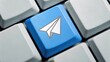 © adaptable_ Lark98A1 - Blue keyboard key featuring a paper airplane icon, symbolizing communication and messaging.