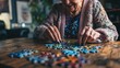 © Zheng - Elderly woman concentrating on solving jigsaw puzzle at wooden table, senior mental exercise and cognitive stimulation for memory care and dementia prevention.
