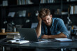 © Di Studio - stressed male student studying with laptop and books