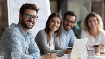 Wall Mural - team of entrepreneurs smiling during productive team meeting, planning startup goals, laptops and co