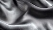 © zong - Close-up of smooth, shiny, silver-gray fabric with soft folds and subtle texture under gentle lighting