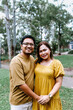 © Austockphoto - Portrait of happy Asian couple standing at the park