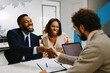© djile - Couple meeting with financial advisor shaking hands after successful discussing investments and financial planning