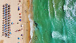 © Alex Tihonov - Aerial view of Dehesa de Campoamor beach on Costa Blanca. Straw umbrellas, sandy shoreline, turquoise Mediterranean Sea. Summer holidays, travel, tourism, coastal relaxation. Alicante province, Spain