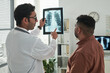 © pressmaster - Middle aged Caucasian male doctor showing chest X ray to middle aged Hispanic man during diabetes consultation in medical office, both standing and discussing diagnostic results