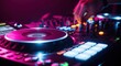 © Farhan - A DJ's hand is seen adjusting knobs on a professional audio mixer and controller during a live set at a nightclub, surrounded by vibrant pink and blue lights.