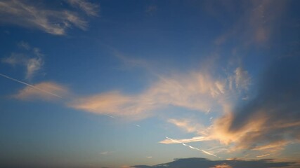 Wall Mural - a sunset sky timelapse with soft golden-orange clouds gently spreading across a clear blue canvas, h