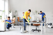 © Pixel-Shot - Team of young janitors cleaning in office
