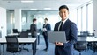 © 순단 강 - A Korean man in a suit holding a laptop computer to the right, with luxury office furniture in the blurred background