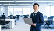 © 순단 강 - A Korean man in a suit holding a laptop computer to the right, with luxury office furniture in the blurred background
