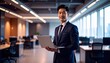 © 순단 강 - A Korean man in a suit holding a laptop computer to the right, with luxury office furniture in the blurred background