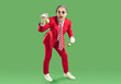 © Studio Romantic - Excited surprised male Santa Claus holding New Year tree toys and keeping mouth widely opened, suggesting to buy Christmas decor, wears red costume , isolated over green background
