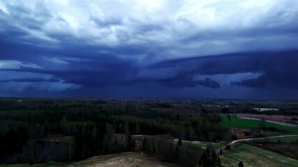 Wall Mural - panoramic view of thunderstorm sky over agricultural land, dark blue sky rayleigh scattering phenome
