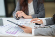 © aekachai - Two businesswomen are sitting in a meeting, planning investment plans, business strategies. On the table are documents and graphs.