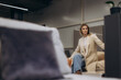 © Roman - Stylish Woman Sitting at a Furniture Showroom Display in Casual Attire