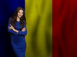 © millaf (Nemchinova) - Brunette young woman in blue dress smiling against Romanian flag background