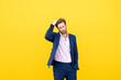 © VISTA by Westend61 - Confident businessman in suit standing against yellow wall