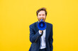 © VISTA by Westend61 - Businessman with megaphone against yellow background