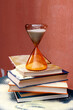 © VISTA by Westend61 - Hourglass on a stack of books with sand spilling over indoors
