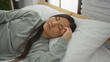 © Krakenimages.com - Woman sleeping peacefully on bed in cozy bedroom with soft lighting highlighting her serene expression and relaxed posture indoors.