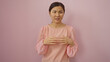 © Krakenimages.com - Woman in pink blouse standing against isolated pink background looking thoughtful with hands gesturing
