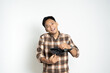 © Hardollin - Asian man in a plaid shirt poses playfully with an open wallet, expressing a lighthearted moment. Perfect for concepts of humor, emotions, or finance illustration.