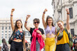 © daniromphoto - Four smiling women raising fists at gay pride parade celebrating lgbtq+ rights