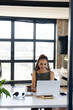 © Wavebreak Media - African American woman working at desk in office using laptop stand with headphones and smartphone