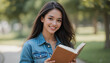 © Azhar's stock - Woman Holding Book Smiling in Denim Jacket Outdoors