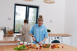 © SHOTPRIME STUDIO - Active middle age woman preparing healthy salad in bright kitchen, surrounded by fresh vegetables and fruits, promoting wellbeing and wellness lifestyle.