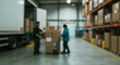 © birulaut - Two workers load boxes from a warehouse onto a truck for delivery.
