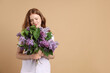 © New Africa - Beautiful teenage girl with bouquet of lilac flowers on beige background. Space for text