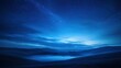 © Maksum Udod - A tranquil blue night sky over rolling hills and misty valleys captures a serene atmosphere of peace and calmness in nature.