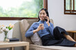 © Kainnika - Asian woman at home talking on the phone with her friend.