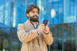 © Andrii Iemelianenko - Indian Arabian man tourist chatting on internet on mobile phone standing outdoors. Happy smiling young Lebanese guy using cellphone typing email message communicate by SMS on downtown city street.