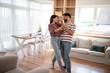 © Migma_Agency - Happy couple dancing together in modern living room