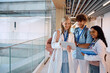 © Drazen - Group of happy medical and nursing students using digital tablet in hallway.